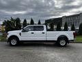 White 2020 Ford F-250 Super Duty pickup truck with a four-door cab and chrome wheels parked on a driveway