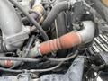Close-up of the engine components of a 2008 Hino 268 showing various pipes hoses and attachments with a focus on a large rubber hose and metallic fittings