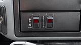 A close-up view of the control panel of a 2005 International 4300 featuring two switches labeled PTO and BEACON