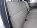 The image shows the interior back seat of a 2009 Ford F-450 SD with beige fabric upholstery and seatbelts attached