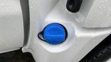 Close-up of a blue diesel exhaust fluid cap on a 2021 International CV515 vehicle with water droplets on its surface