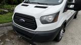 A 2017 Ford Transit van with a white exterior and a black grille featuring the Ford logo on the front