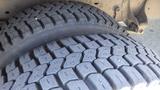 Close-up of two worn tires from a 2011 Ford Econoline showcasing detailed tread patterns