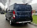 A 2020 Ford Transit van in dark blue with a rear view showcasing its large cargo space and modern design features