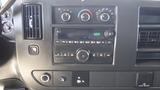 Dashboard of a 2015 GMC Savana featuring climate controls a radio display and various buttons and knobs