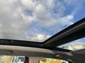 The interior view of a 2015 Fiat 500L showcasing a panoramic sunroof with a clear sky visible above