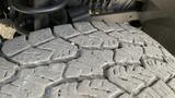 Close-up of a worn tire tread on a 2013 RAM 2500 showing deep grooves and uneven wear patterns on the rubber surface