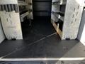 Interior of a 2021 Mercedes-Benz Sprinter van featuring shelving units on both sides and a clean black floor without obstacles