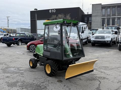 A 1994 John Deere F1145 utility vehicle with a green body and yellow snow plow attachment at the front