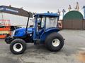 A blue 2007 New Holland TN70A tractor with large tires and a protective cab shown from the side