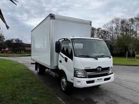 A white 2018 Hino 195 box truck with a large cargo area and a chrome grille facing forward