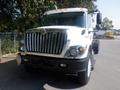 A white 2009 International 7400 truck with a prominent chrome grille and multiple lights on the roof facing forward