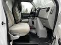 Interior of a 2017 Ford Econoline showing two front seats and a center console with cup holders