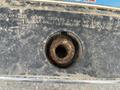 Close-up of a rusty fuel filler neck on a 2010 Dodge Ram showing wear and corrosion on the metal surface