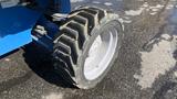 Close-up of a tire on a 2008 Genie S-65 Boom Lift showcasing its rugged tread pattern and metal wheel rim