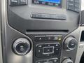 Dashboard controls of a 2014 Ford F-150 featuring various buttons and knobs for sound settings air conditioning and volume adjustment