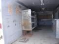 An empty 2010 Forest River Enclosed trailer with metal shelves and a work table inside