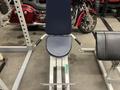 A gym equipment set featuring a flat bench with a padded seat and backrest along with adjustable handlebars for a workout station