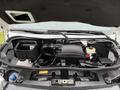 The engine compartment of a 2019 Mercedes-Benz Sprinter showing the engine components and various fluid reservoirs