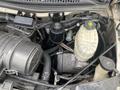 View of the engine compartment of a 2018 Chevrolet Express showing the air intake, oil filter, and various fluid reservoirs with connected hoses