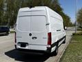 A white 2022 Mercedes-Benz Sprinter van parked on the side of the road showcasing its rear and side profile with a large cargo area and distinctive branding