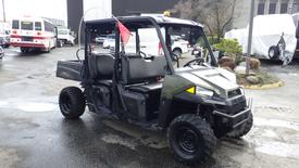 A 2021 Polaris Ranger Crew side-by-side vehicle with an open cab two rows of seating and off-road tires