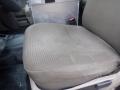 A brown cloth front seat of a 2009 Ford F-450 SD with a flat surface and a seatbelt buckle visible on the side