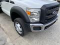 2012 Ford F-550 with a black front grille and chrome trim featuring a large tire with a shiny wheel hub