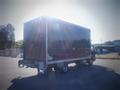 A 2013 Mitsubishi Fuso FE 160 delivery truck with a dark box cargo area parked in an open area