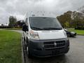 A 2016 RAM Promaster van with a white exterior and black front grille parked on a street