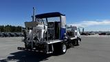 A 2006 Ford LCF 550 truck with a tank and equipment mounted on the back designed for specialized tasks such as liquid transportation or maintenance