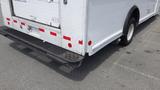 A 2011 Ford Econoline truck with a white body and a visible step bumper featuring red reflective stripes and a loading door