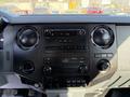 Close-up of the dashboard controls and stereo system of a 2016 Ford F-350 SD featuring dials buttons and a digital display