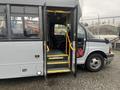 A 2017 Chevrolet Express with the door open revealing steps leading to the driver's seat and interior of the vehicle