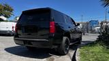 A black 2018 Chevrolet Tahoe parked with its back facing the viewer showcasing its rear design and tinted windows