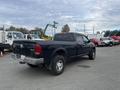 A black 2010 Dodge Ram truck with a crew cab and a 4x4 badge parked with its rear facing the viewer