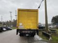 Yellow 2018 International 26 foot cube truck with air brakes parked on the street facing away from the viewer