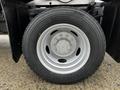 Close-up of a tire and wheel from a 2012 Ford F-550 featuring a silver rim and treaded black tire