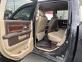 Interior of a 2010 Dodge Ram with beige leather seats and a brown panel on the door trim showing the front and rear seating areas