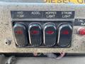 Control panel with four black switches labeled HYD PUMP ACCEL HOPPER LIGHT and STROBE LIGHT illuminated with red indicators