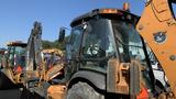 A 2015 Case 580 backhoe loader with a cab and front loader attachment showcasing its operational features