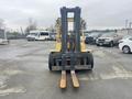 A yellow 2000 Hyster 120 forklift with two metal forks extending forward is positioned prominently in the foreground