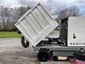 A 2007 Tennant Sentinel cleaning machine with its waste container tilted for emptying showcasing its mechanical components and design