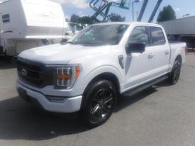 A 2022 Ford F-150 in white with black accents and alloy wheels showcasing its bold front grille and streamlined design