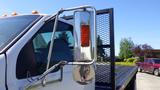 A 2006 Ford F-650 with a large side mirror and a rectangular red light mounted on the side of the truck cab