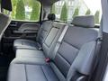 The interior of a 2017 GMC Sierra 1500 showing the rear seat with black fabric upholstery and seat belts