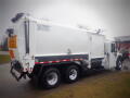 A 2008 International 7400 garbage truck with a white body and red and black accents featuring a rear loader design and labeled Expert 2000