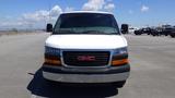 Front view of a white 2012 GMC Savana van with a black grille featuring the GMC logo in the center and visible headlights on either side of the grille