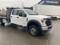 A 2021 Ford F-550 truck with a flatbed design and dark wheels parked in a lot