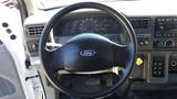 Steering wheel of a 2006 Ford F-650 with a black leather cover and various controls and gauges visible in the dashboard area